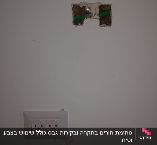 שקע חשמלי בקיר עם חור ותשתית ירוקה